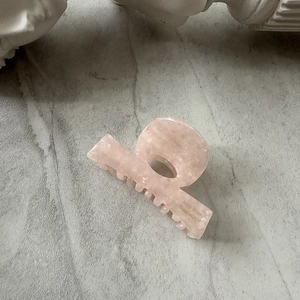 Detail showing marble texture of the Any Bear acetate hair claw clip on stone surface