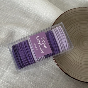 Close-up of purple high-elasticity hair ties neatly organized in a transparent gift box