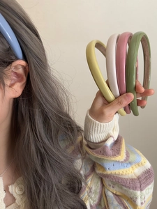Detail showing high-gloss candy colored wide headbands with non-slip fabric inner lining