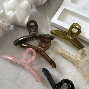 Detailed top view of various colored resin hair claws on marble background