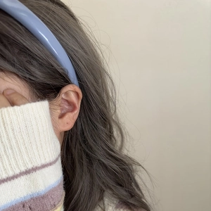 Sweet light blue leather headband worn by a model with dark grey wavy hair
