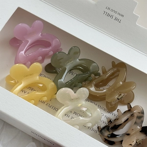 Close-up of six colorful acetate rabbit hair claws in a minimalist white gift box
