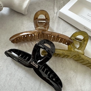 Large acrylic hair claw clips in amber, olive green, and black for thick hair styling