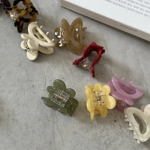 Macro shot of colorful acetate butterfly hair clips in various patterns on grey stone surface