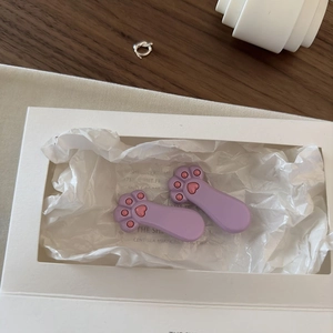 Dettaglio di fermagli per capelli a zampa di gatto in resina viola e rosa in scatola regalo