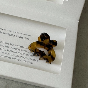 Macro view of leopard print acetate hair claw clip set in a premium display box