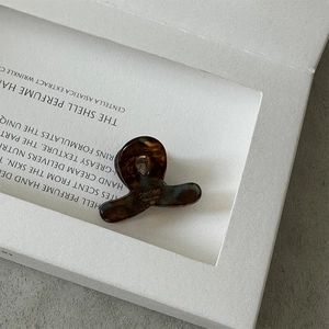 Gros plan d'une mini pince à cheveux en acétate ambré avec motif écaille de tortue
