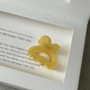 Detail of yellow translucent acetate hair claw with Sunshine Handmade logo engraving