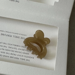 Macro shot of a brown translucent acetate rabbit hair claw clip with smooth resin finish