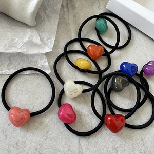 Set of colorful heart hair ties with golden lettering on various vibrant elastic bands