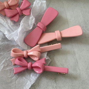 Lot de jolies barrettes roses avec nœuds et rubans sur un fond blanc texturé élégant