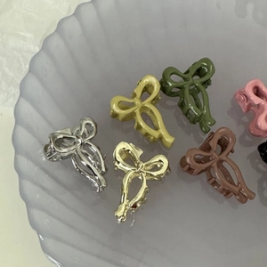 Mini barrettes nœud élégantes en couleurs métalliques sur un plateau vintage