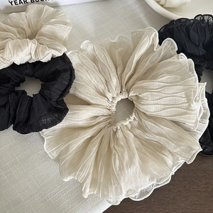 Détail de chouchous plissés surdimensionnés en mousseline de soie crème et noire
