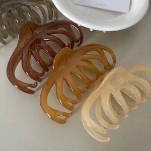 Macro shot of large translucent octopus hair claws in amber and cream tones for thick hair