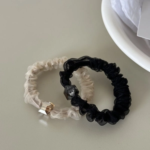 Detail view of two-piece pleated mesh hair ties with transparent faceted square beads