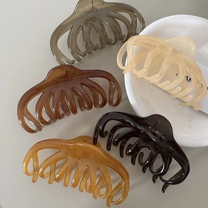 Set of five large translucent daisy hair claws in olive, cream, amber, and black colors