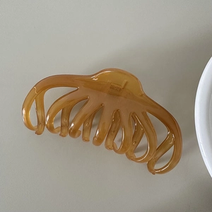 Detail view of large amber translucent octopus hair claw clip for thick hair styling