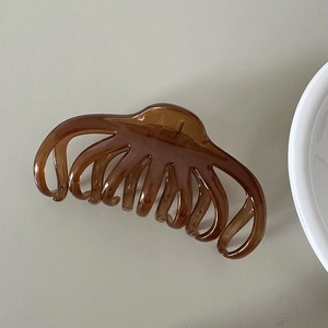 Macro detail of large brown translucent hair claw clip with strong metal spring