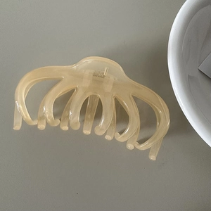 Macro detail of amber resin octopus hair claw clip with durable metal spring mechanism