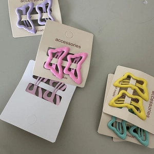 Close-up of pastel butterfly metal hair clips on display cards in multiple colors