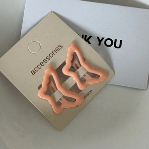 Close-up of a pair of orange butterfly hair clips on a decorative accessories card
