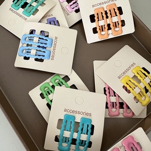 Détail montrant une collection colorée de barrettes à cheveux mates en forme de vague