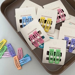 Détail de pinces à cheveux ondulées aux couleurs bonbon avec une finition mate chic