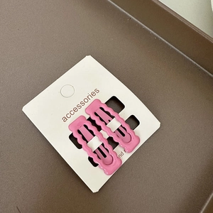 Détail de 2 barrettes à cheveux rectangulaires roses ondulées sur carte d'accessoires