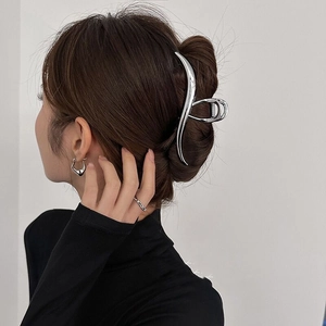 Minimalist silver wavy metal shark clip for hair styling shown on dark hair in a clean look