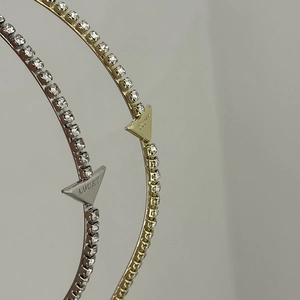 Macro detail of Lucky logo on rhinestone headband in gold and silver finish