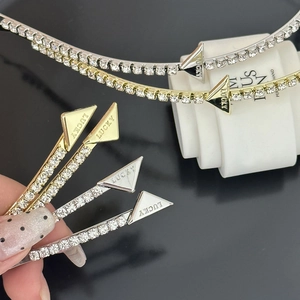 Detail of metal hair clip with rhinestones and LUCKY engraved on the triangular end piece