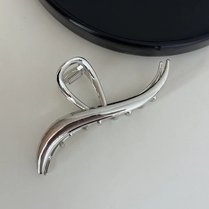 Detail showing the polished silver metal spring mechanism of the minimalist shark hair claw