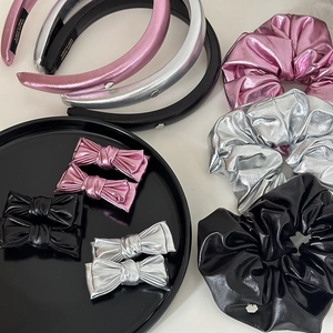 Détail d'un ensemble d'accessoires de cheveux en cuir métallisé rose, argent et noir