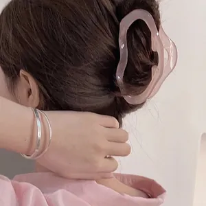 Irregular resin shark hair claw clip in translucent pink for elegant updo styling