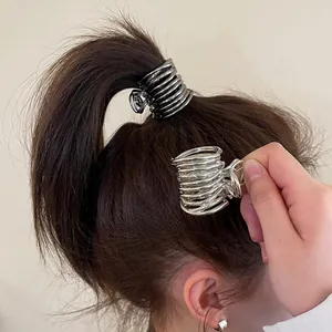Close-up of spiral metal hair claw with polished silver finish on a ponytail