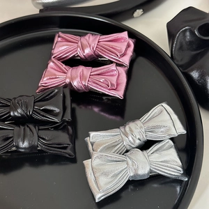 Lot de trois paires de barrettes à nœuds en cuir métallisé rose, noir et argenté