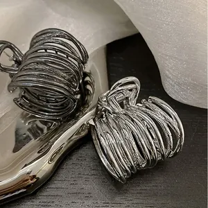 Detailed view of spiral metal hair clips in gunmetal and silver finishes