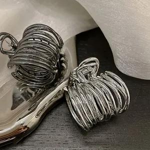 Close-up of hollow metal hair claws in gunmetal and silver finish with textured rings