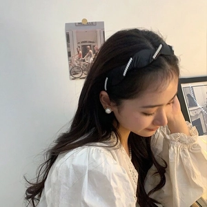 Serre-tête élégant en satin avec perles et rayures porté par un mannequin féminin