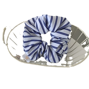 Minimalist blue and white striped fabric scrunchie with a small heart pattern tag