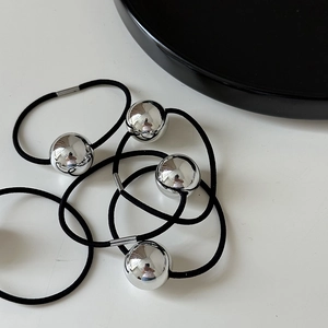 Detail of high-elastic black hair ties featuring polished silver metallic spheres