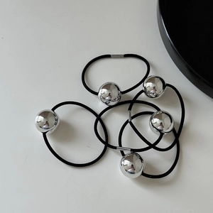 Close-up of five black elastic hair ties featuring polished silver metal spherical beads
