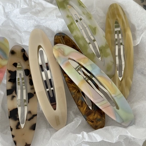 Detailed macro view of assorted acetate marble hair clips with silver metal backings
