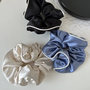 Three-piece set of satin scrunchies in black, blue and beige with white contrast edging