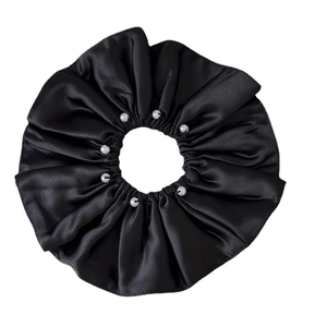 Elegant large black satin scrunchie with white pearl accents on white background