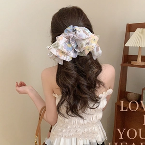 Detail of floral organza scrunchie with pastel flower pattern on a ponytail
