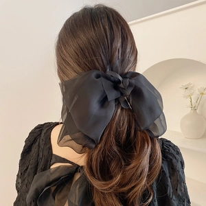 Detail of multi-layered black sheer tulle bow hair clip on model back view