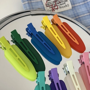 Close-up of colorful matte hair clips in vibrant jelly tones arranged on a mirror