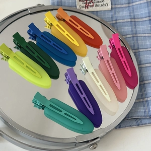 Detailed macro view of 10-piece matte hair clips set displayed on a round mirror surface