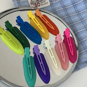 Set of ten matte colorful seamless hair clips displayed on a reflective mirror surface